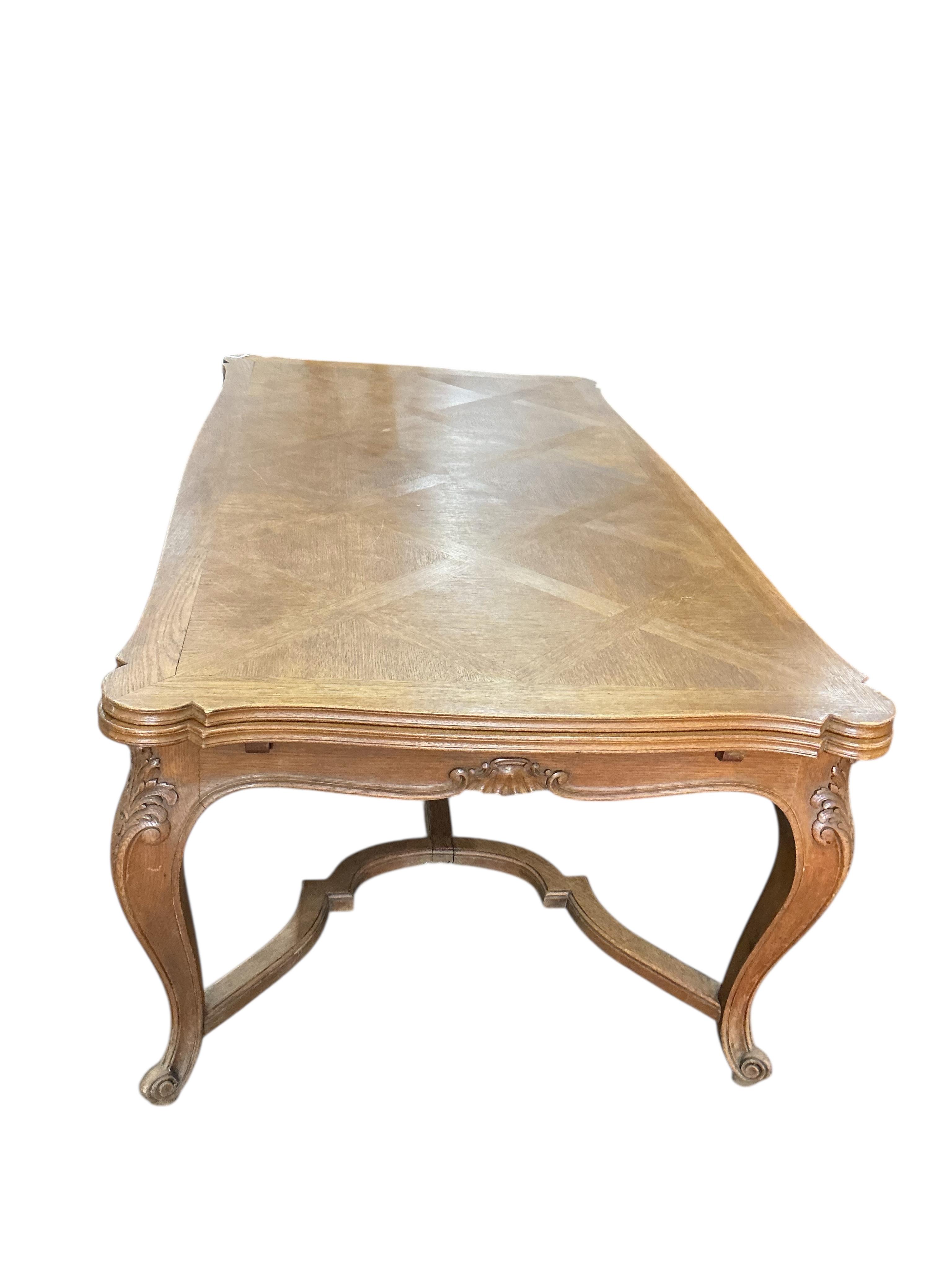 A French rectangular parquetry draw leaf dining table on acanthus carved cabriole legs, width 199cm, (320cm extended), depth 119cm, height 76cm